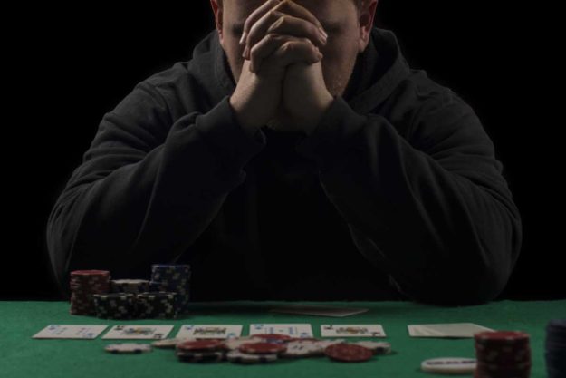 person in dark playing cards alcohol and gambling