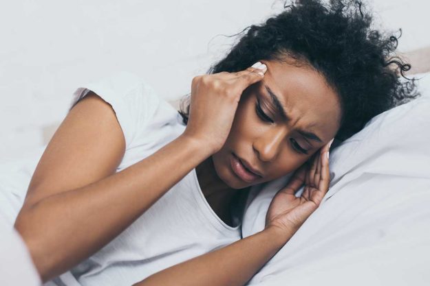 woman in bed dealing with designer drugs side effects