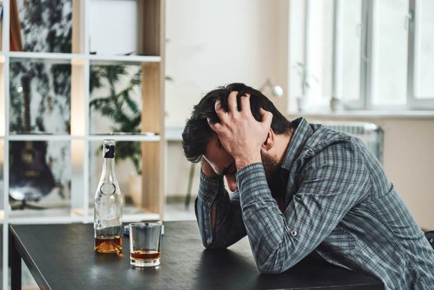 a man deals with the symptoms of alcohol addiction